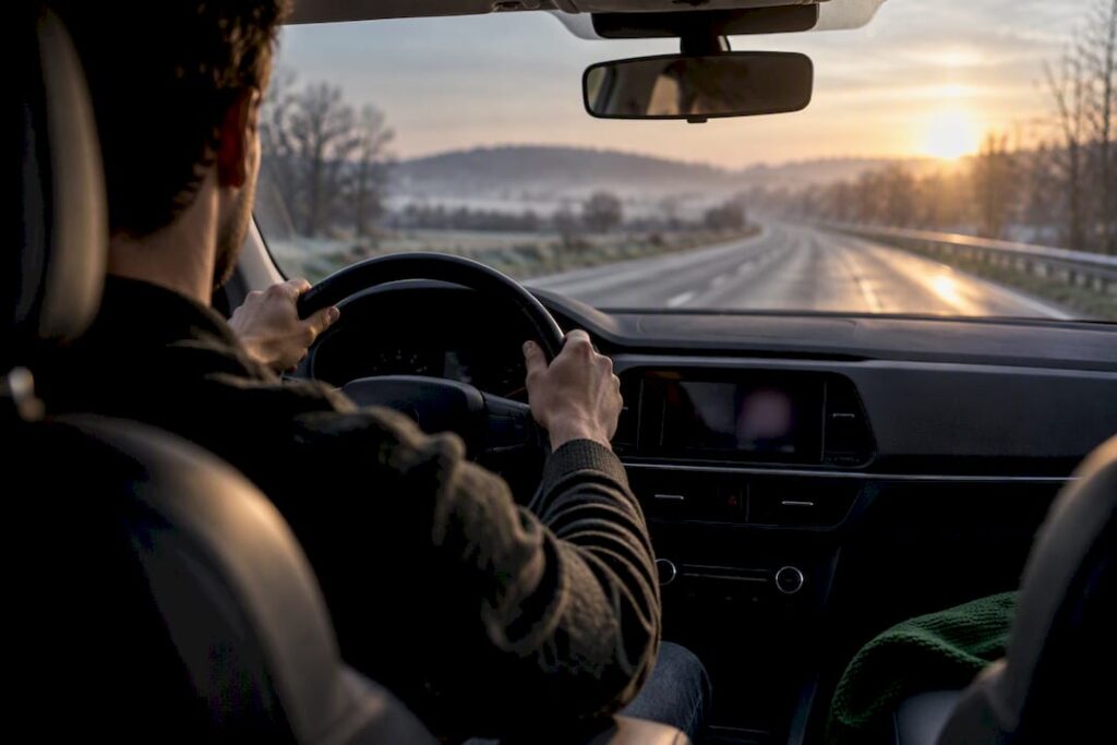 Conducteur tenant le volant sur une route en France